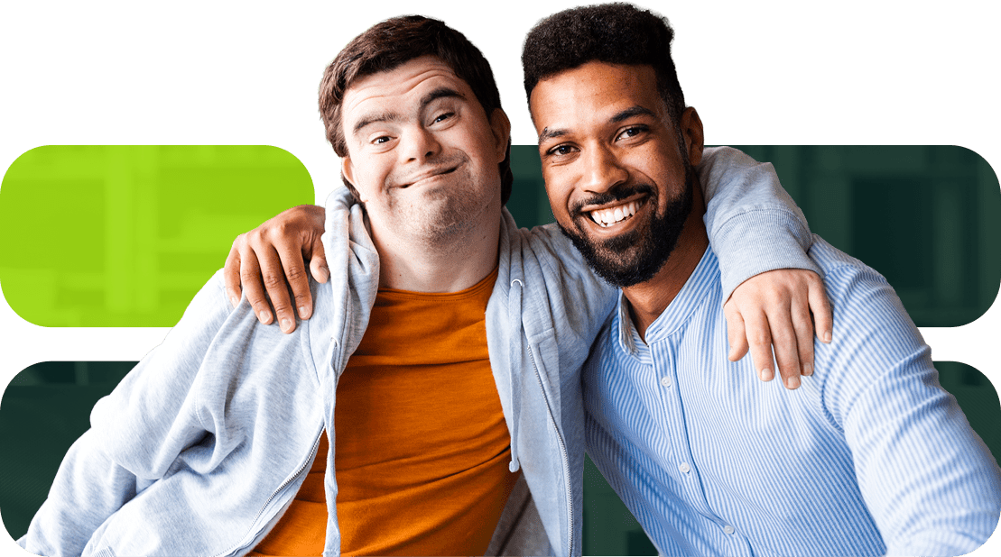Two young men, one smiling widely with Down syndrome and the other with a beard, pose together with arms around each other, showcasing friendship and inclusivity.